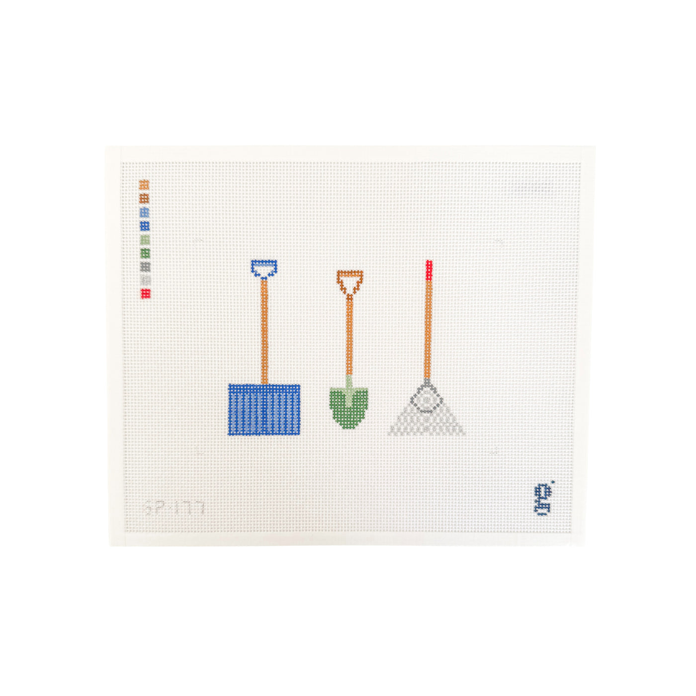 white rectangular needlepoint canvas with blue snow shovel, green garden shovel, and silver rake at center