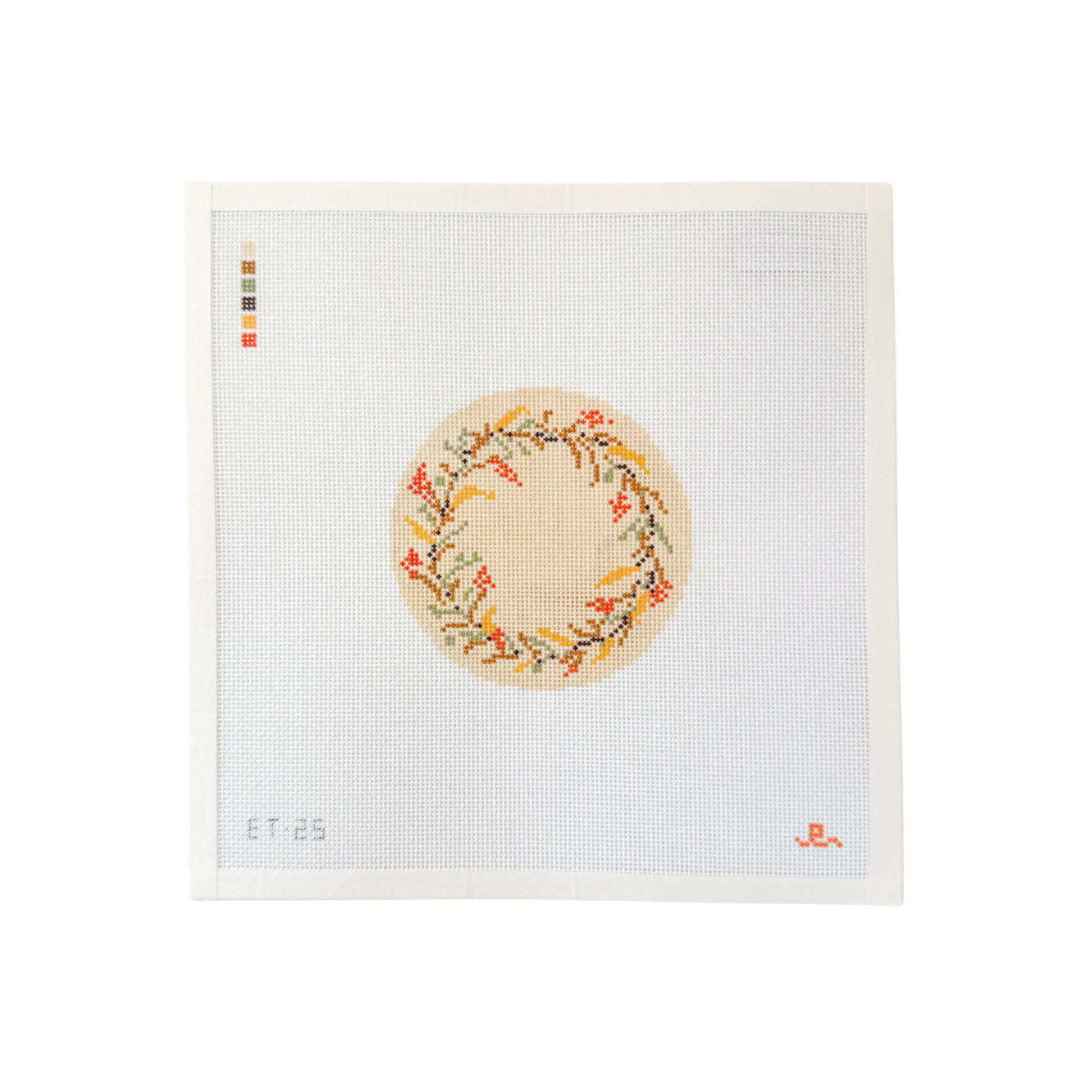 White square needlepoint canvas with tan circular design at center featuring a wreath of autumnal flowers
