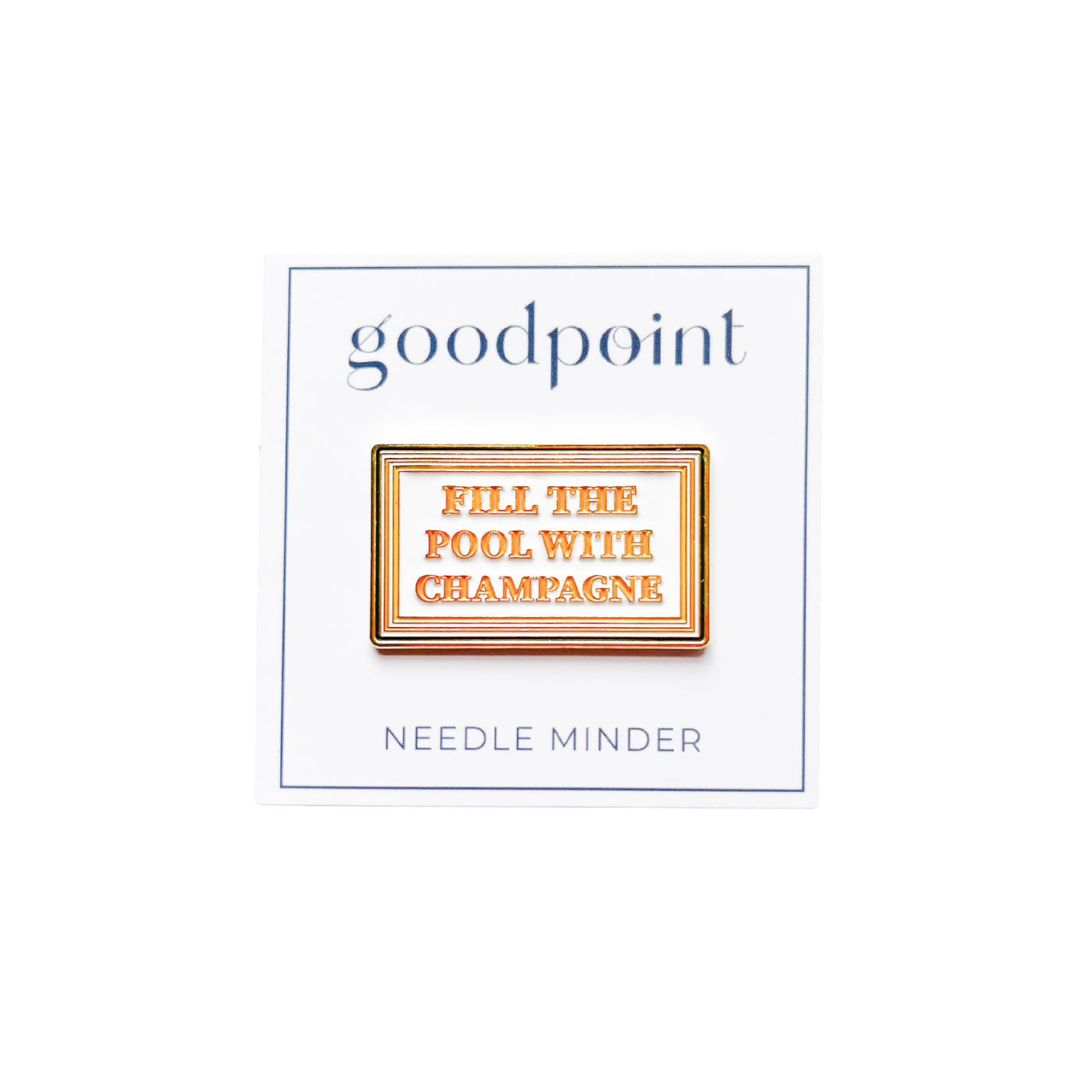 White card stock with the goodpoint logo holds an enamel needle minder with a green, orange and gold striped border and the words Fill the Pool with Champagne in orange at center