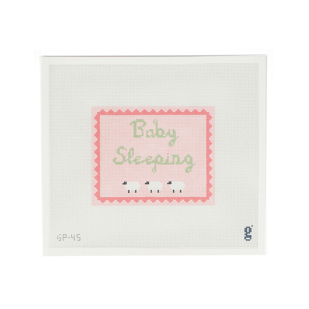 White needlepoint canvas with pink rectangular design featuring a darker pink scallop border and the words "Baby Sleeping" in green script font. Below which are 3 white sheep.