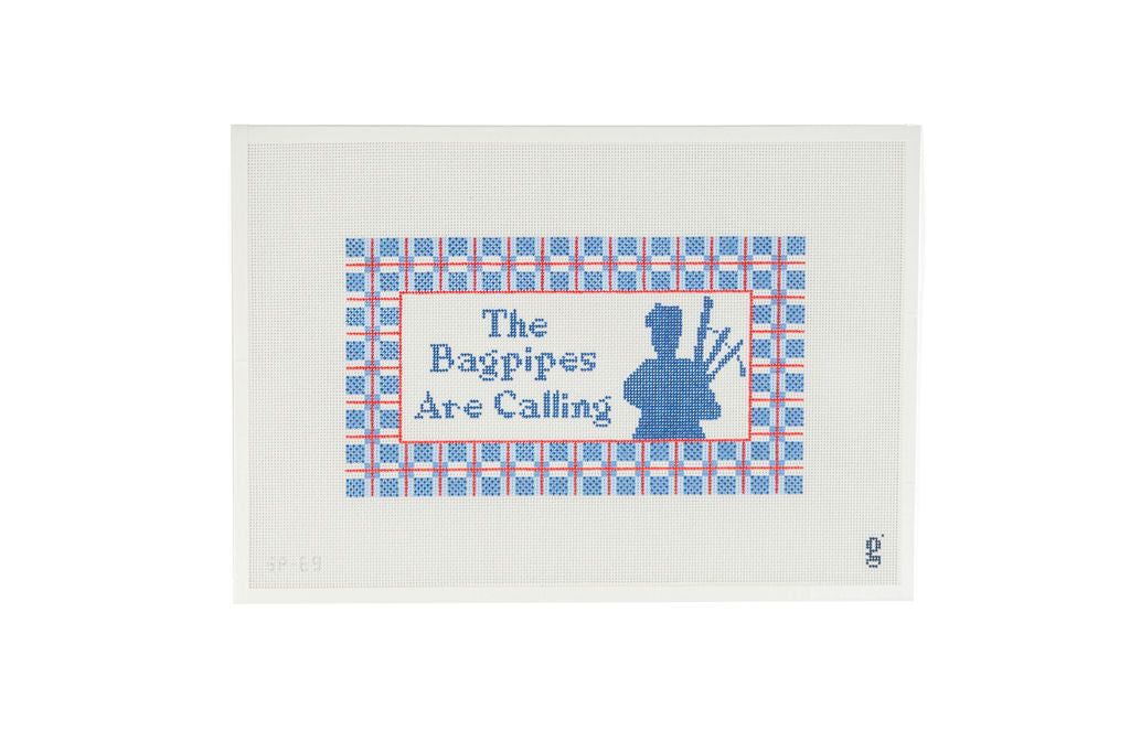 White needlepoint canvas featuring a light blue, navy and red design of a tartan plaid border with the words "The Bagpipes Are Calling" at center next to a silhouette of a Bagpiper.