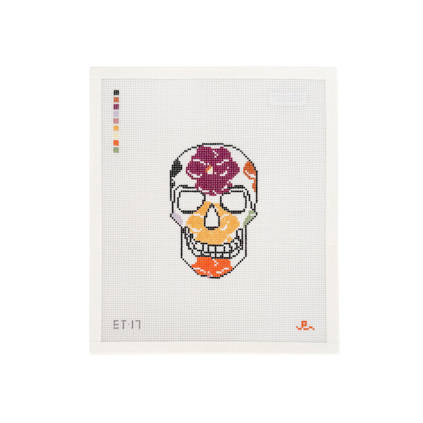 White needlepoint canvas with black skull design filled with autumnal colored pansy flowers throughout