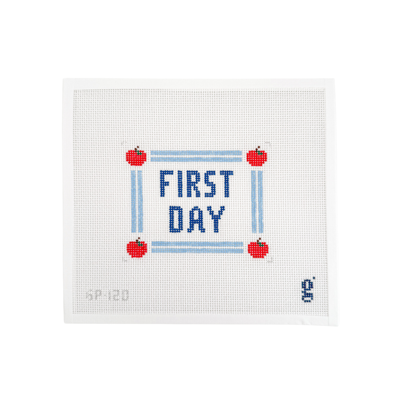 White needlepoint canvas with navy block text in center reading "FIRST DAY" with light blue double stripe border with red apples at each corner