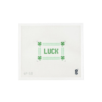 White needlepoint canvas with the word LUCK in green text at center, surrounded by a mint green striped border and 4 leaf clovers at each corner