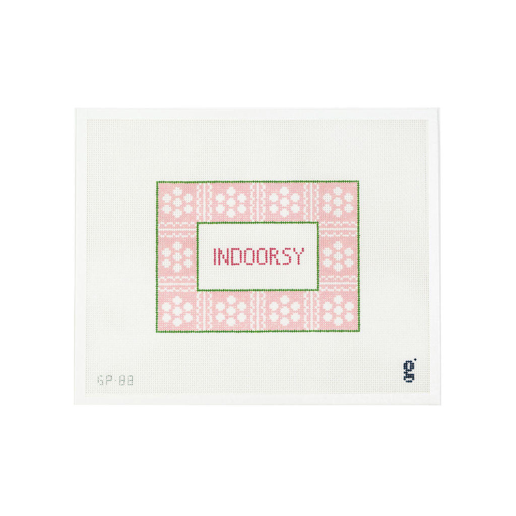 White needlepoint canvas with light pink border with white daisy flowers divided with white scalloped design. The word "Indoorsy" is at center in bright pink.