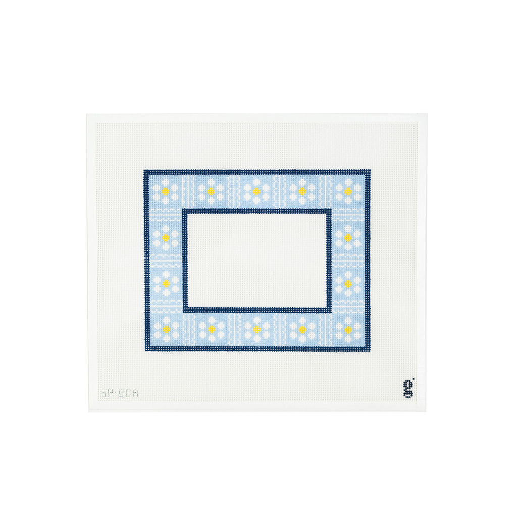 White needlepoint canvas with blue painted border with white and yellow daisies divided by white scallop details 