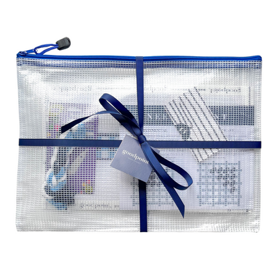 Needlepoint project bag filled with supplies is tied up with a navy grosgrain ribbon