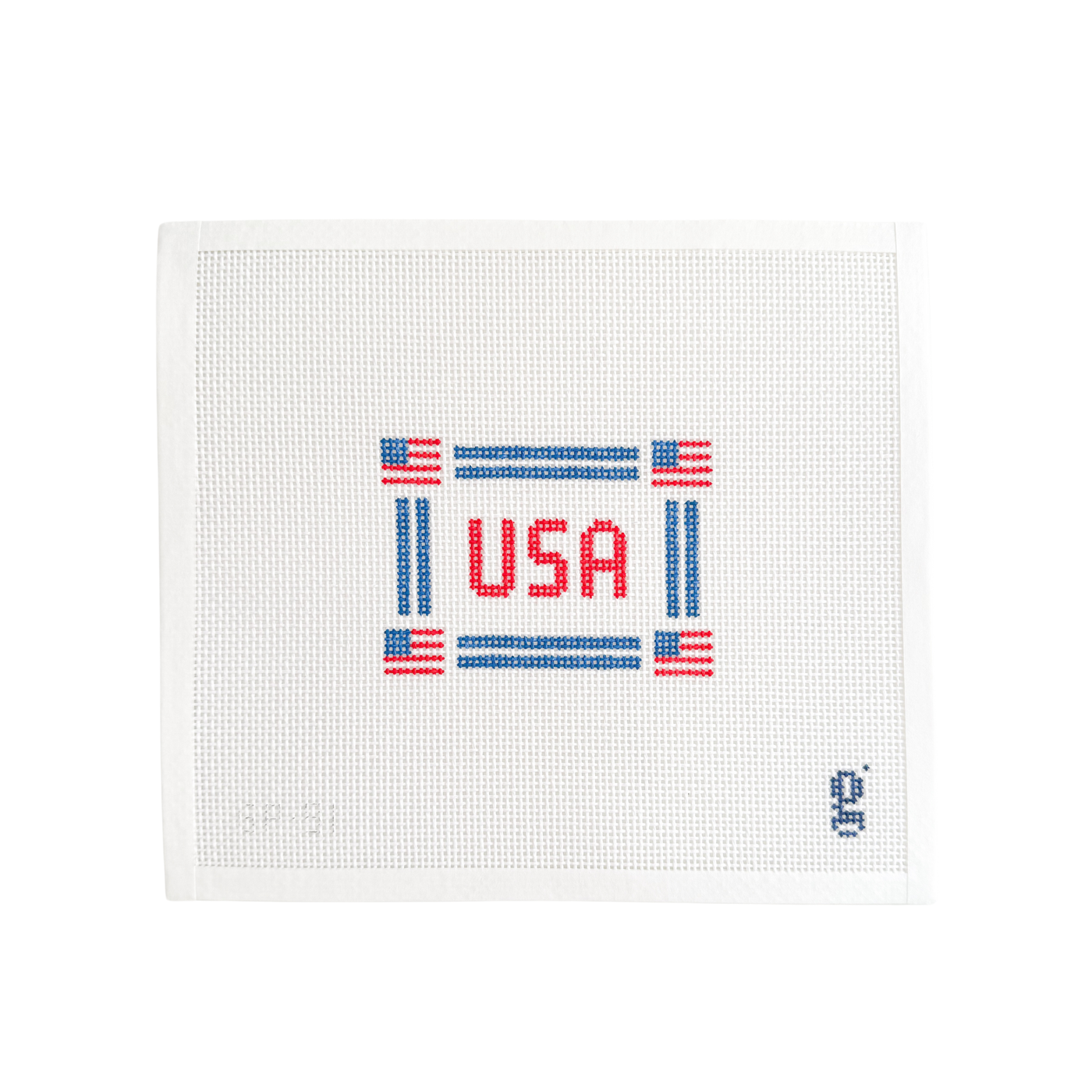 White needlepoint canvas with navy border with American flags at each corner and the word "USA" in red block text at center